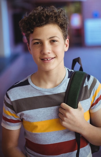 happy-schoolboy-standing-school-campus