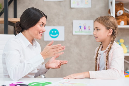 smiling-portrait-girl-female-psychologist-having-conversation-office